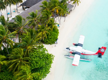 float plane apporaching tropical beach